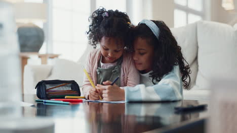 two young sisters drawing and coloring together at home