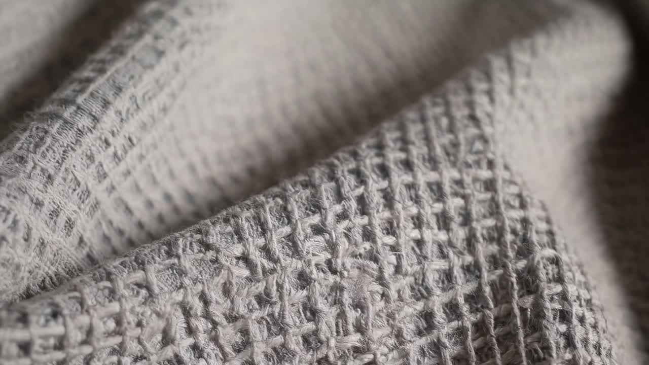 Detailní záběr texturované látky s malou hloubkou ostrosti, zvýrazňující složité vzory