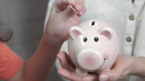 dropping coins into piggy bank.