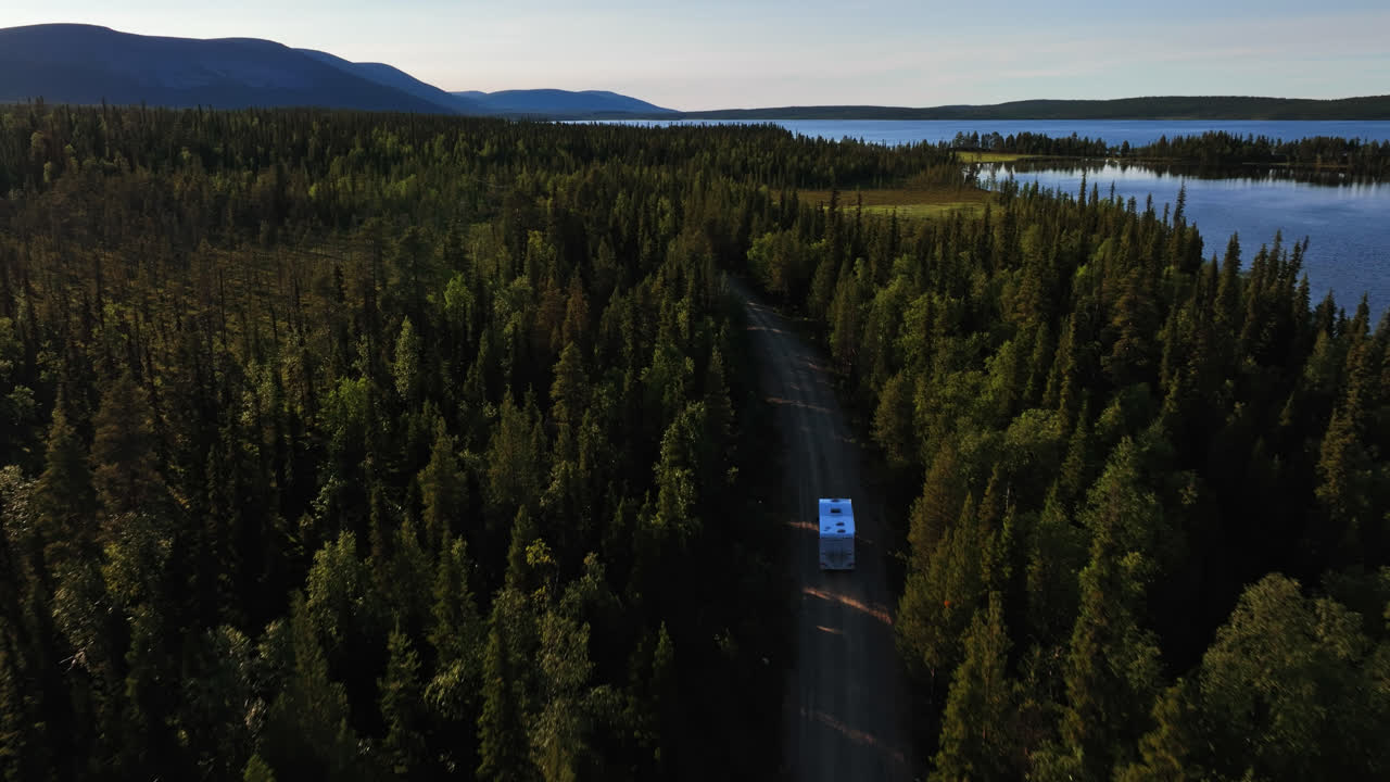 Pallasjarvi Gölü yakınında ilerleyen bir karavanı takip eden drone, Lapland'da yaz.
