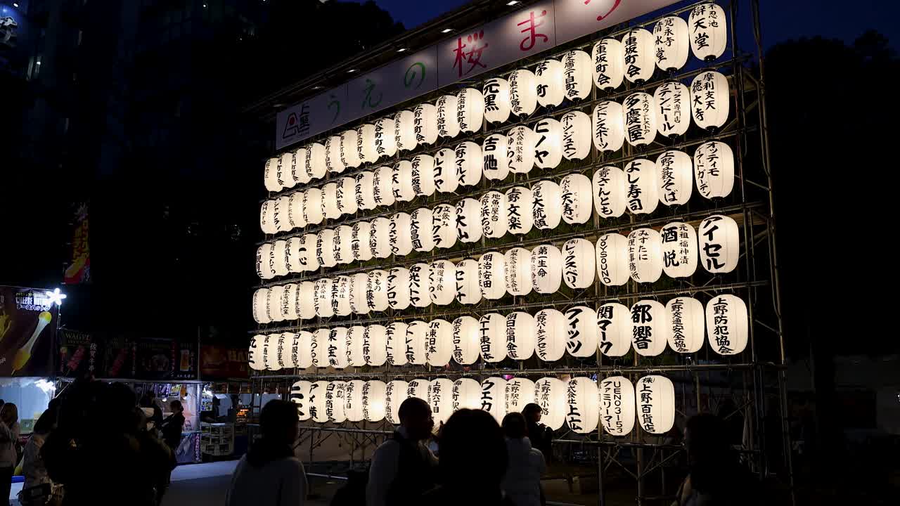 Udstilling af belyste japanske lanterner på nattefestival med mennesker