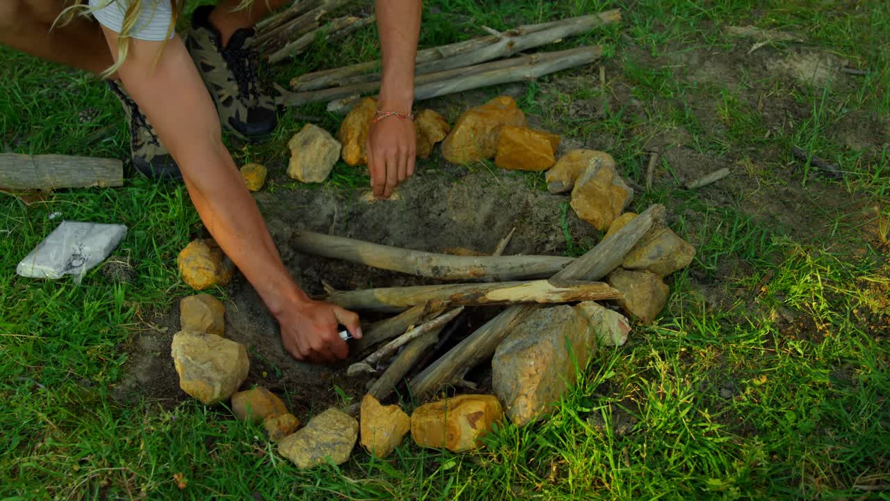 Man lighting campfire in the forest 4k