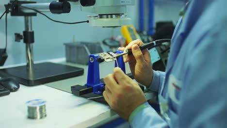 soldering is done on the microchips in the factory with a soldering machine. electronic working hands.4.