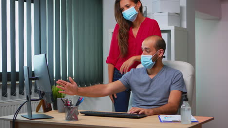compañeros de trabajo con máscaras faciales trabajando