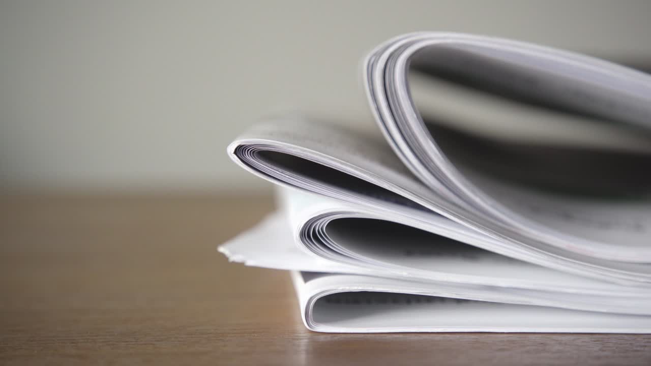 Lifting and placing a stack of newspaper on a table