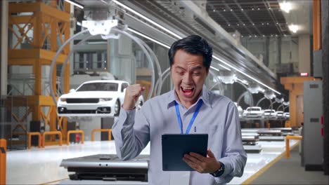 happy factory worker celebrating success with tablet