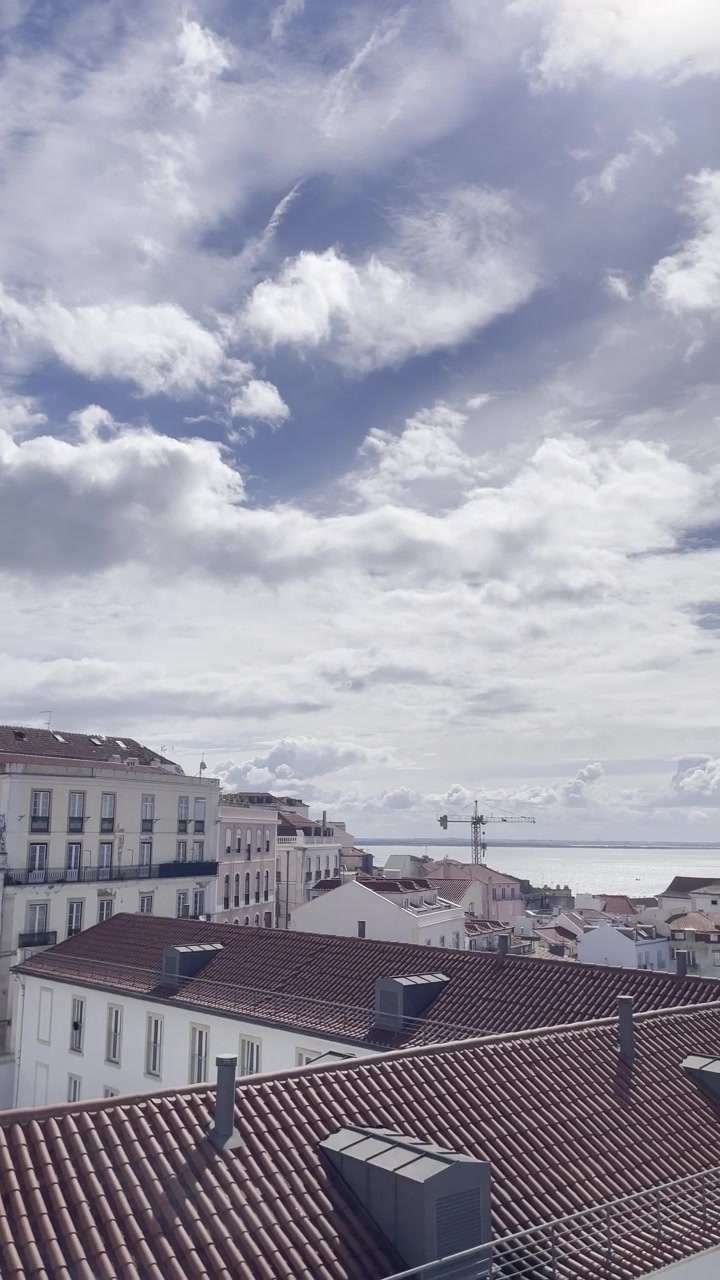 Miradouro Portas do Sol, Lisbona. Punto panoramico di Lisbona, Portogallo, attrazione turistica popolare ad Alfama. Scatto panoramico da telefono, skyline cittadino, giornata di primavera luminosa e soleggiata con nuvole.