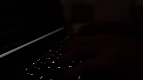 Toma-Misteriosa-Oscura-De-La-Pantalla-De-La-Computadora-Hasta-Las-Manos-En-El-Teclado,-Concepto-De-Hacker-De-Ciberdelincuencia