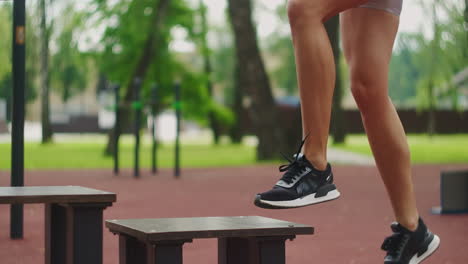 athletics trains in the park on a bench performing lunges squats on one youth