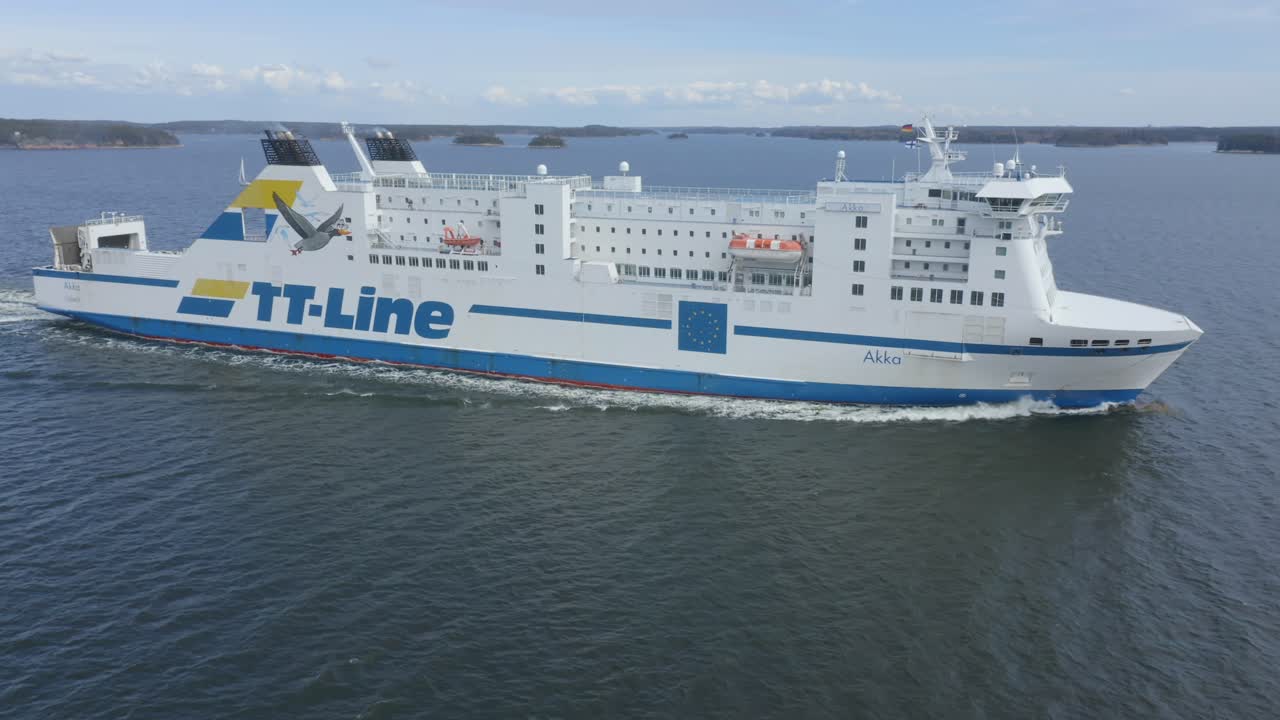 TT Line car ferry AKKA making way ahead in Finnish archipelago. Low altitude aerial circling view.