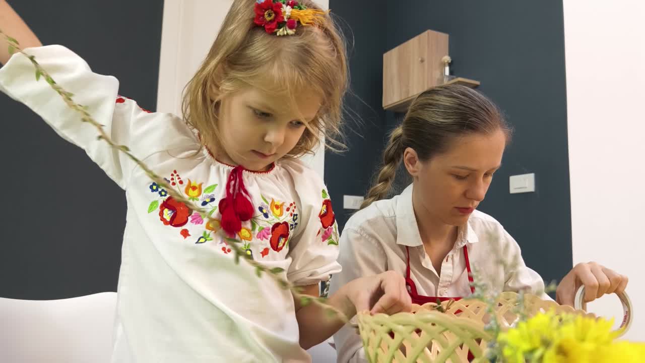 Mother and daughter making a floral basket decoration