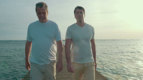 dos hombres teniendo una conversación durante una caminata en el muelle