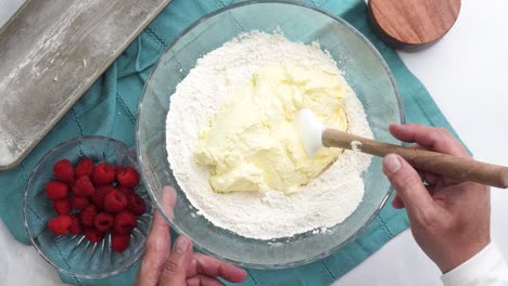 making a dessert called red raspberry tea cake made with fresh berries and vanilla buttercream frosting. great for tea parties. mixing the vanilla cake batter in a bowl and combing the ingredients