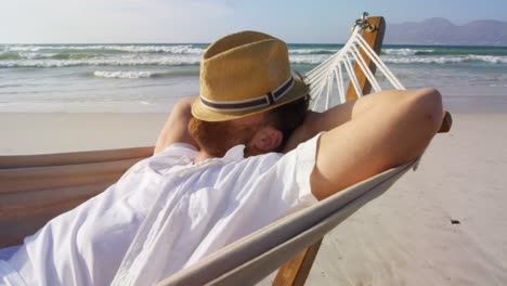 Man-sleeping-in-hammock-at-beach-4k