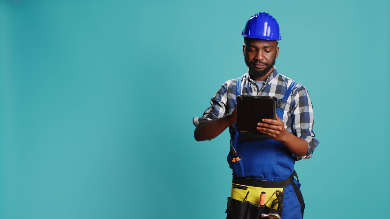 Young handyman using digital tablet on camera