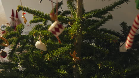 indoor christmas tree with daytime lighting, decorated with colorful ornaments