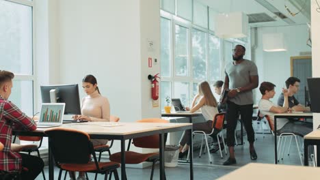 serious man coming in coworking space. black man planning to work in open space.