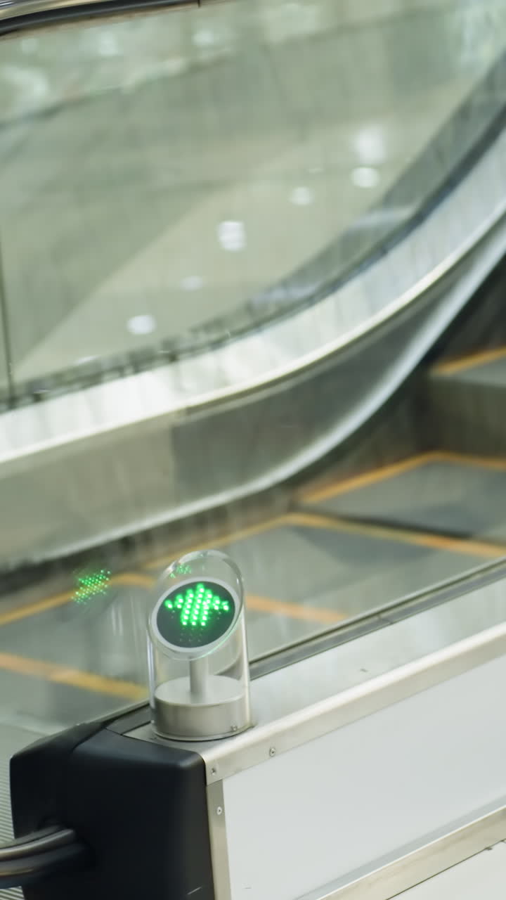 una escalera mecánica en movimiento en un centro comercial moderno. el video muestra a alguien subiendo a la escalera mecânica, capturado con una cámara de mano, destacando los detalles de las escaleras móviles
