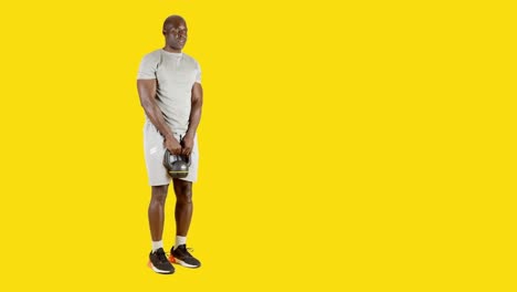 african man dead lifting with kettlebell and one leg raised