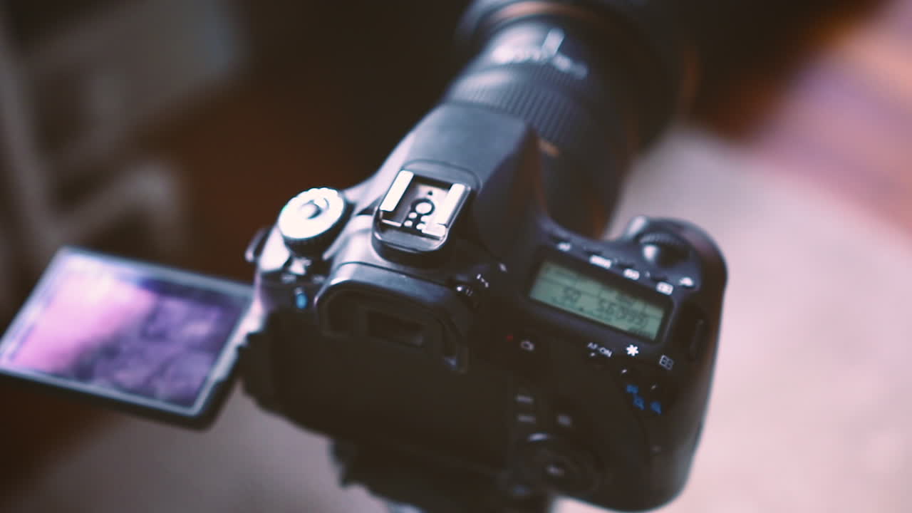 A DSLR camera attached to a photographic tripod