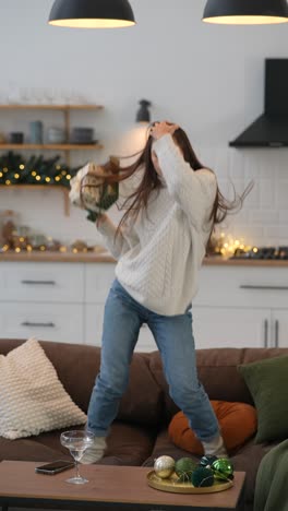 woman celebrating christmas by jumping on sofa