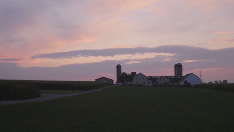 sunrise over amish farmlands with a colorful sky on a misty summer morning timelapse