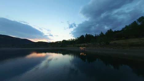 Toma-Aérea-Hacia-Atrás-Del-Bosque-Verde-Y-El-Lago-Inmóvil