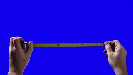 male hands holding measuring tape on blue chroma key background. close up. 4k resolution.