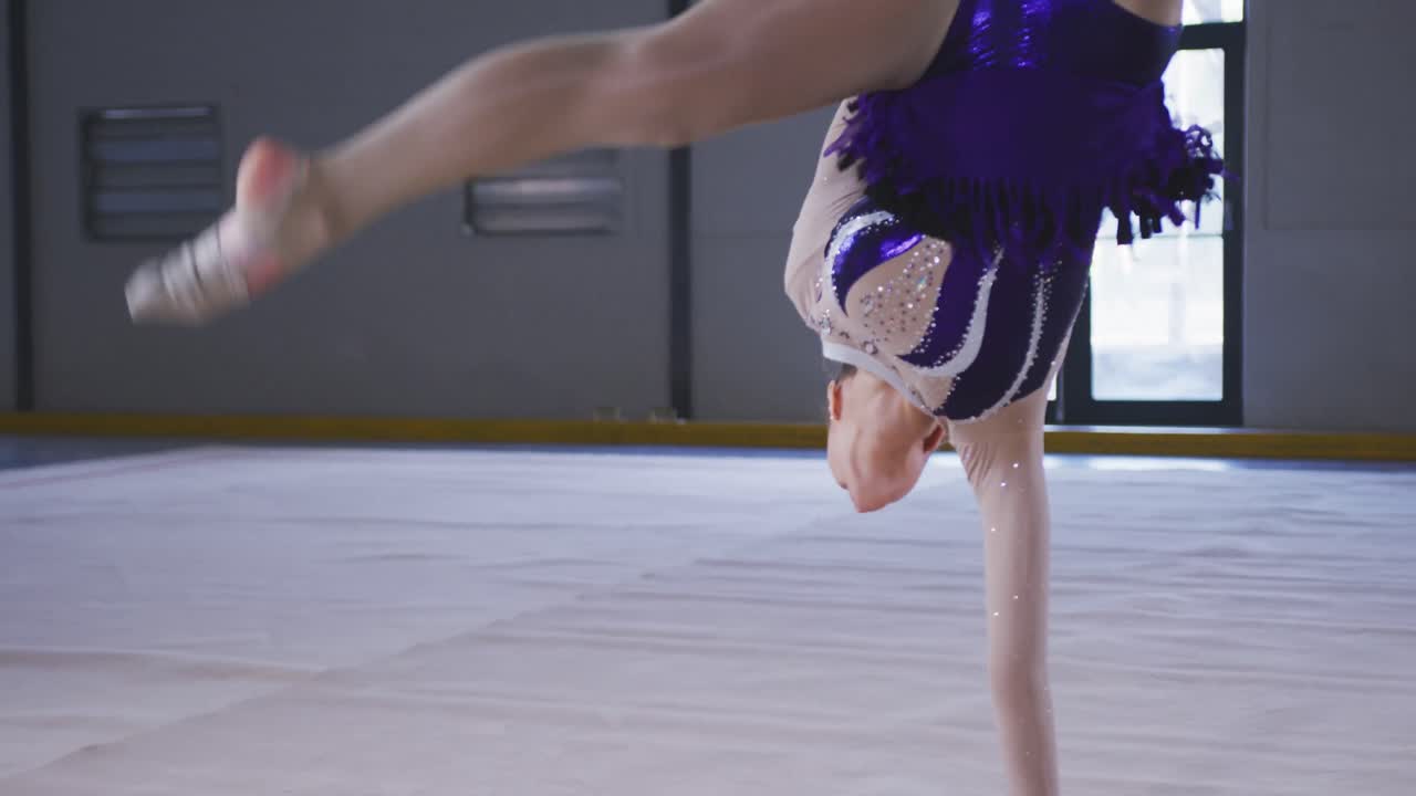 Ginnasta adolescente in esibizione in un palazzetto dello sport