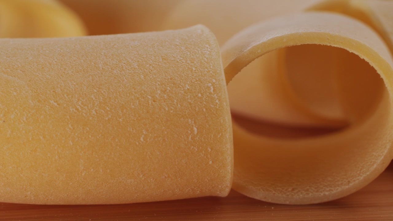 Vista dettagliata di pasta cruda su uno sfondo di legno rustico