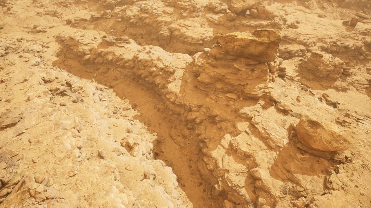 Dramatic rocky landscape with tracks in arid environment during daylight hours