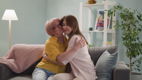 young woman hugs mother, elderly woman