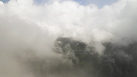 un avión no tripulado pasa a través de nubes y niebla sobre el clásico bosque de pnw en el estado de washington en un día soleado