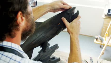 craftsman working on fish sculpture 4k