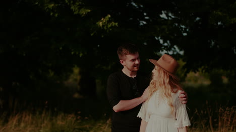 young man supporting woman outdoors in summer