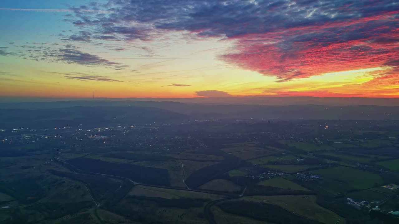 무인 항공기 영화 같은 시골 풍경 녹색 안개가 자욱한 들판 화려한 빨간색 일몰 수평선 불 같은 구름