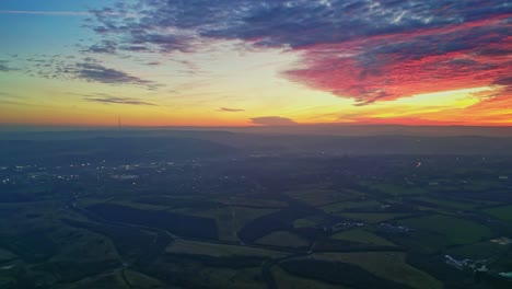 Drone-Cinemática-Campo-Paisaje-Verde-Brumoso-Campos-Colorido-Rojo-Atardecer-Horizonte-Ardiente-Nubes