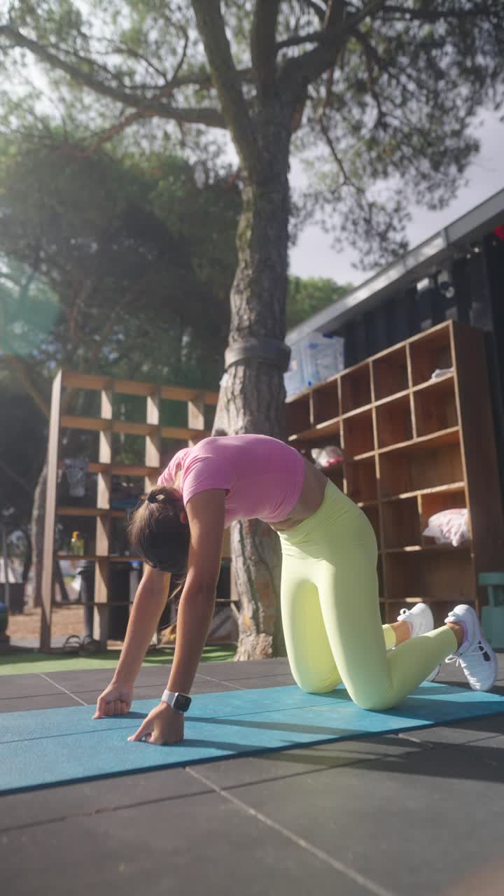 Woman performing outdoor yoga and stretching on a mat