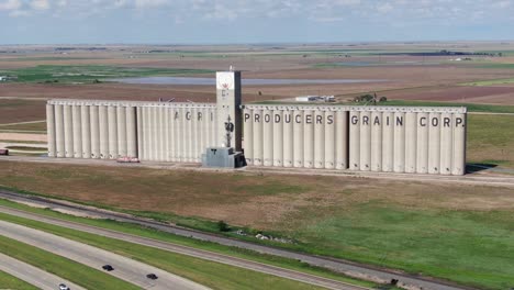 massive grain silo just north of the city of plainview, tx, dwarfs rail cars and other surrounding things.