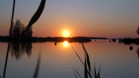 majestuosa puesta de sol de medianoche en la región nórdica junto al lago, vista en movimiento