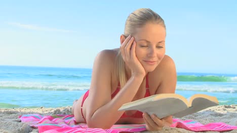 una mujer rubia bonita leyendo una novela.
