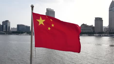 chinese national flag blowing around famous landmark, the bund, in downtown