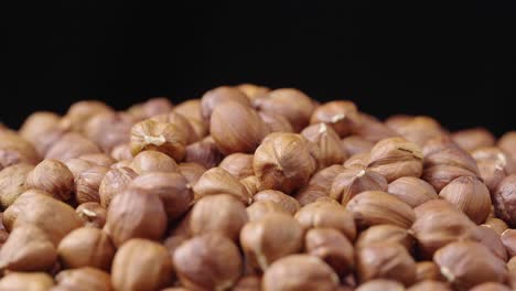 pile of shelled hazelnuts on a black background