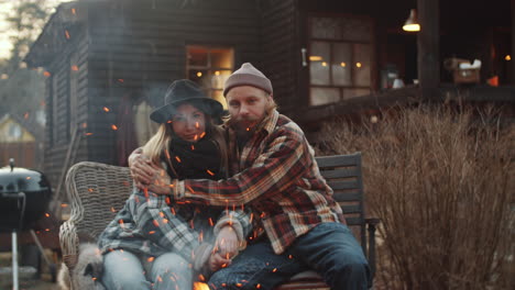 portrait of loving couple embracing by bonfire