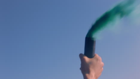 cerca de la mano de la mujer sosteniendo humo verde granada concepto de señal de rescate