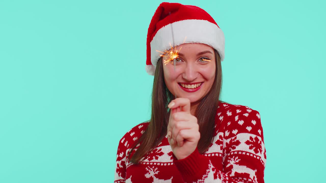 Lovely girl in christmas santa sweater dancing with bengal sparklers fireworks ligts congratulation