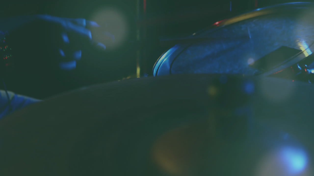 Batterista che suona il rullante sotto luci di scena fredde blu e verdi, con una sovrapposizione animata di forme d'onda.