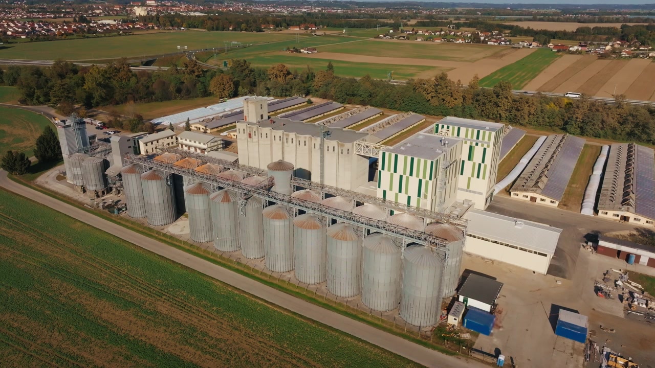 Eine Luftaufnahme von Getreidesilos und landwirtschaftlichen Lagereinrichtungen in einer ländlichen Gegend mit Feldern in der Nähe.