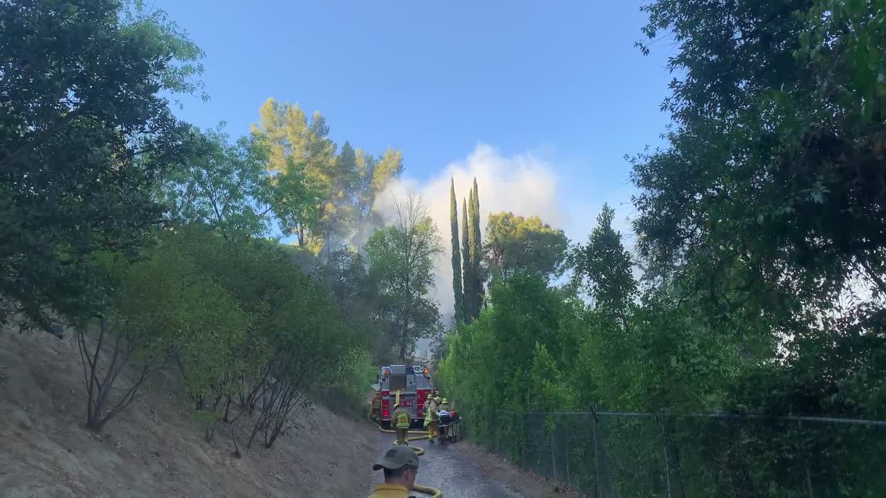 los bomberos establecen líneas de mangueras en el incendio de la estructura