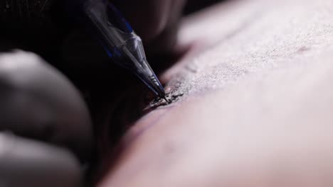 tattoo artist hand in gloves during tattooing procedure